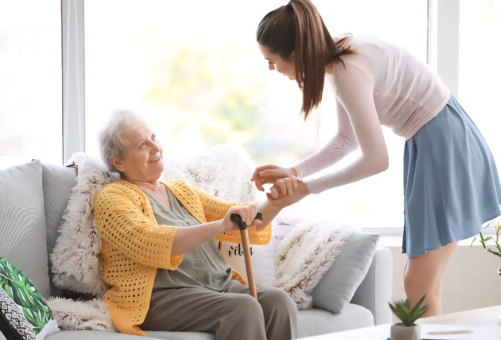 Home care caregiver assisting elderly client with daily living and personal support services